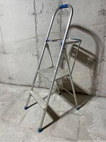 Full view of the aluminum step ladder showing three steps, platform, and rubber feet on legs.