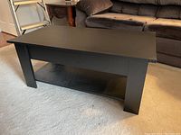 Front view of the black coffee table in a living room setting.