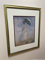 Framed print hanging on wall showing full piece with gold frame and double matting.