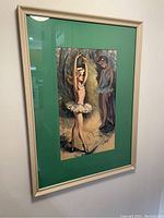 Framed artwork featuring a young ballerina and a male figure, with a green mat and light-colored frame.