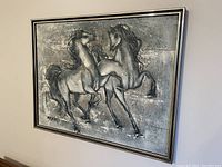 Framed art print showing two stylized horses in silver and gray tones.