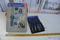 Complete view of the unopened Tool Tech marking and levelling tool set and the 10-piece Mastercraft screwdriver set with handles visible.