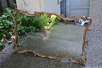 Front view of the wall mirror showing the ornate gold coloured frame and reflective glass surface.