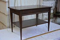Front view of vintage wooden end table with tapered legs and flat top surface.