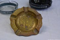 Brass 1939 New York Worlds Fair ashtray showing patina and engraved text around rim and a central emblem