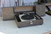 Overall view of the vintage portable record player with the lid open and two speakers on either side.