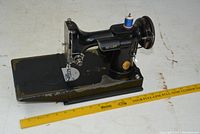 Side view of Singer sewing machine on base with ruler for scale
