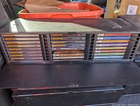 Front view of one black plastic multi-disc holder showing multiple classical, blues, and jazz CD spines