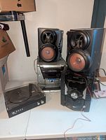 Wide view showing two Sharp speakers, stereo receiver, and turntable on table