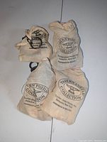 Four cloth bags containing Tavern Puzzle Collection bar puzzles, showing logo and text