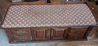 Hope chest top view showing patterned upholstery and the chest structure with drawers and doors.