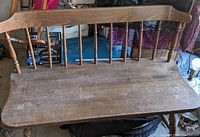 Top view of the wooden bench seat and backrest showing wear and scratches on the wood surface.