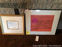 View of two artworks side by side, smaller painting framed in gold-toned frame to the left, larger vibrant red abstract print framed in black to the right.