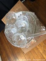 Overhead photo displaying clear glass cups with floral patterns stacked inside a punch bowl.