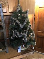 3 ft artificial Christmas tree with silver tinsel and baubles on electric rotating base