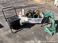 Photo showing black tripod folding stool, green folding stool with lunch bag, two helmets (gold and white), and other sports items inside plastic bin.