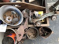 Wooden tray box with various metal washers, nuts, bolts in several containers, and vintage clamp-on ice skates and a single roller skate