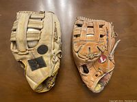 Two vintage adult leather baseball gloves placed side by side showing front and back views, detailing color and wear