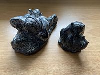 Two handmade wolf sculptures on wooden surface showing detail and size difference.