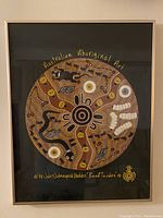 Front view of the framed Aboriginal artwork titled "Bush Tucker" by Julie Nabangardi Shedden. The art features circular patterns and traditional dot painting techniques in earth tones.