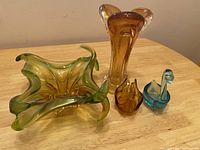 Full group photo of all four colored glassware items on a wooden table for visual overview