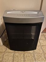 Front view of Fellowes JB01 paper shredder showing black mesh waste bin and silver top control panel.
