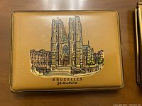 Top view of the vintage Bruxelles souvenir case showing detailed illustration of St. Gudula Cathedral and the text 'BRUXELLES St-Gudule'.