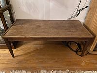 Top view of the wooden coffee table showing the rectangular shape and surface wear.