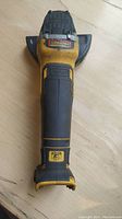 Front top view of the yellow and black DeWalt cordless angle grinder showing the body and trigger area with 'XR' branding on the base.