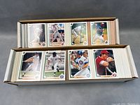 Two open boxes filled with baseball cards arranged for display, showing varied players in different batting, pitching, and running poses