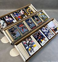 Boxes containing large quantities of hockey cards organized with top cards visible showing players in various jerseys.