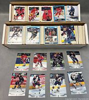 Boxed large collection of hockey cards stacked with visible front cards showing players in team uniforms.