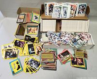 Wide view of all trading cards including football and entertainment cards arranged in piles and boxes.