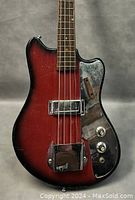 Front view of bass guitar showing sunburst body, pickup and control knobs