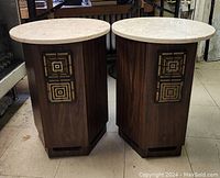 Two speakers front view with round marble tops and woodgrain cabinets