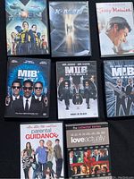 Photo of 8 DVD cases including X-Men First Class, X-Men, Jerry Maguire, three Men in Black films, Parental Guidance, and Love Actually.