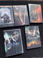 Five DVD cases including three Hobbit movies and two Harry Potter DVDs