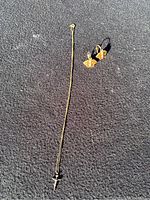 Full view of gold-tone necklace with Saint Christopher cross pendant and gold-tone earrings on surface.