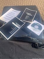 Top view of Ion Profile Pro turntable with three manuals and a CD on top