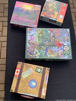 Four puzzle boxes arranged on black surface showing puzzle images and box conditions