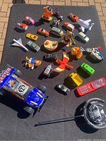 Overview of all toys including remote control car, miniature cars, animals, airplane, and boat.