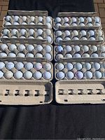 Top-down image of 96 TaylorMade golf balls in cardboard trays showing arrangement and condition.