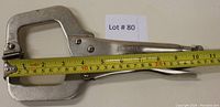 Side view showing overall length of clamp as 10 inches with measuring tape alongside, lot number noted in background.