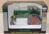 Front view of Oliver Super 88 Diesel Tractor model in original black and clear packaging box with green, red, yellow colors on model visible.