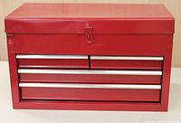 Front view of the red metal tool chest with lock mechanism and two drawers.