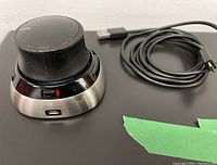 3DConnexion Space Mouse with visible USB-C charging port and charging cable coiled beside it