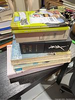 Stack of assorted fashion books and catalogues with DVD tin on top