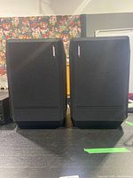 Front view of two black Bose 301 Series IV bookshelf speakers side by side with fabric grills and Bose logo on the right.