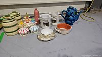 Wide shot of all items including canisters, pixies, vase, fondue sets, teapot, bowl, cup and saucer