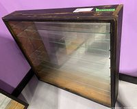 Full view of wood frame glass display case with fold-up glass front door, showing six glass shelves inside with one shelf visibly chipped.